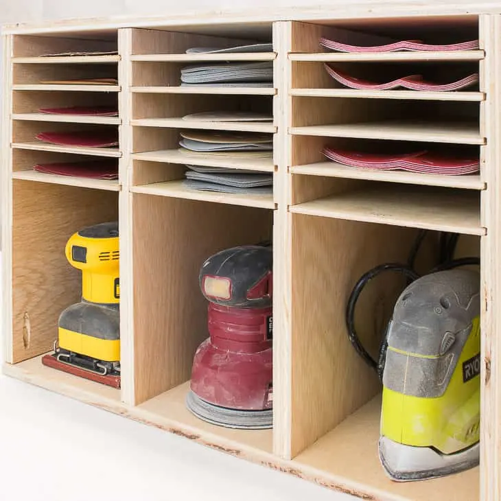 sander and sandpaper storage box on bottom shelf of Kreg workbench