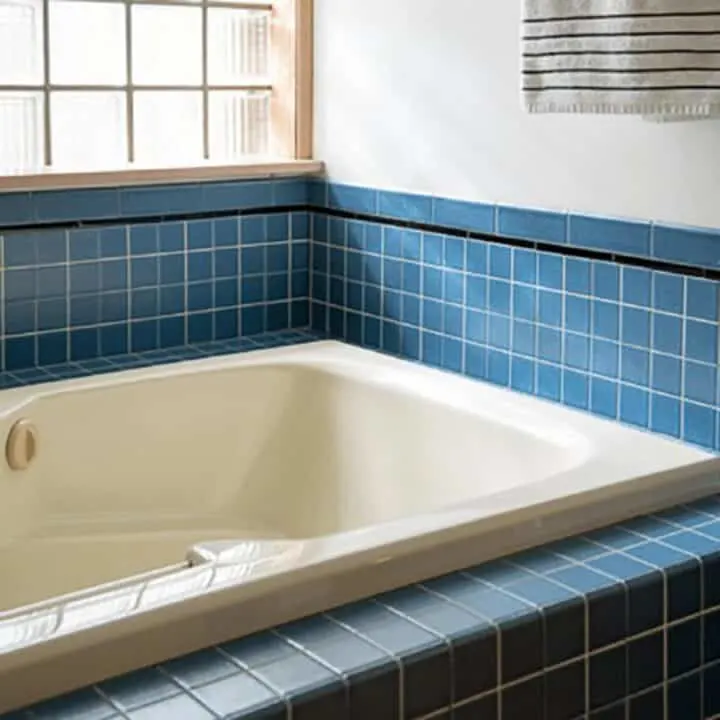 closeup image of almond bathtub and blue tile