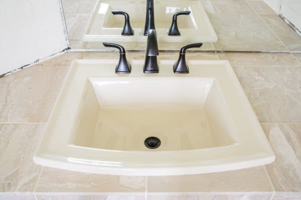 limestone tile countertop with almond sink and oil rubbed bronze faucet