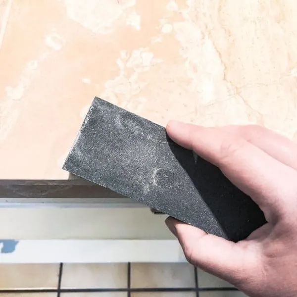 using a tile sanding stone on corner of limestone tile