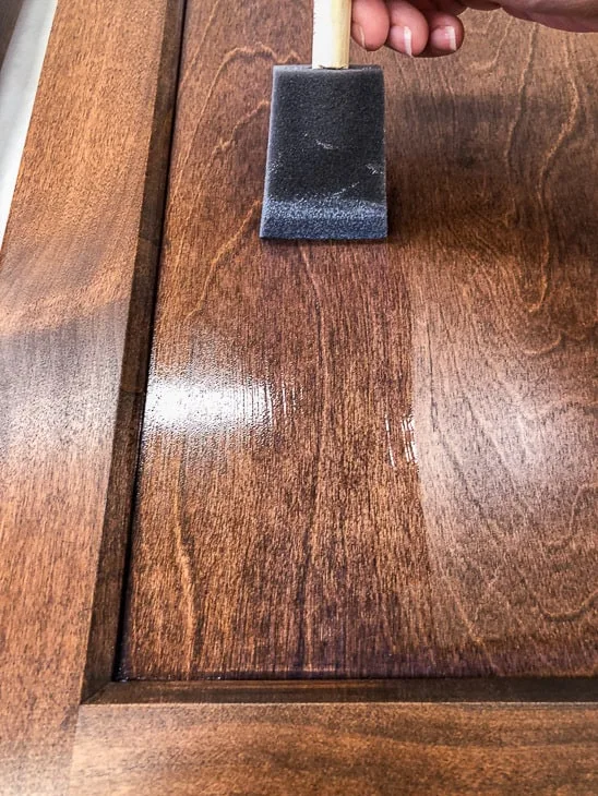 brushing on top coat on new cabinet doors