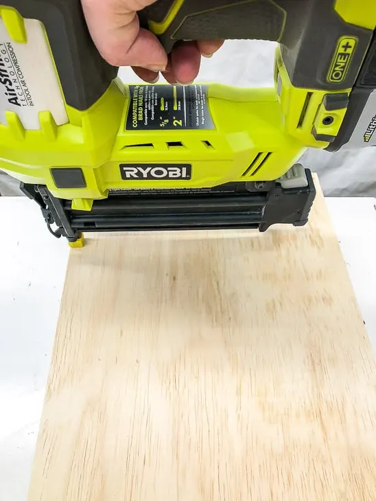 nailing the back of recessed bathroom shelves in place with a Ryobi Airstrike brad nailer