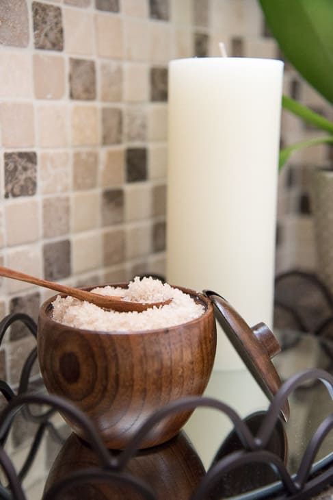 bath salts in wooden bowl with spoon and candle