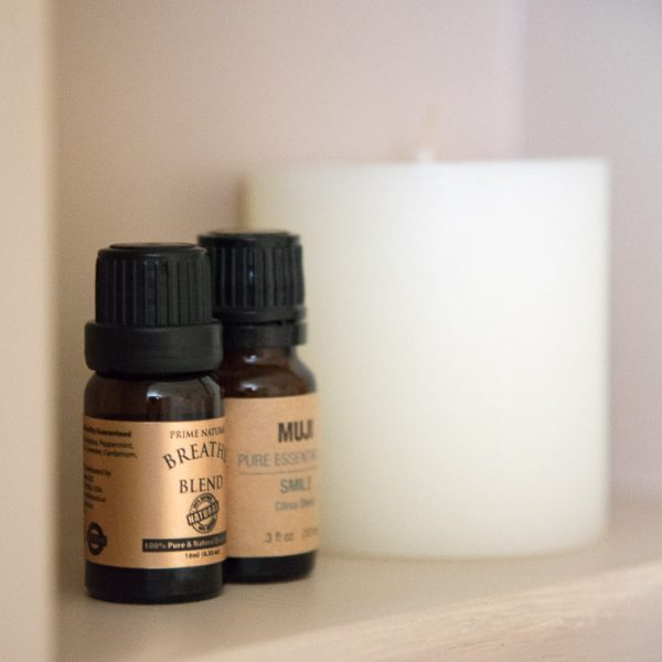close up view of essential oils and candle in recessed shelves