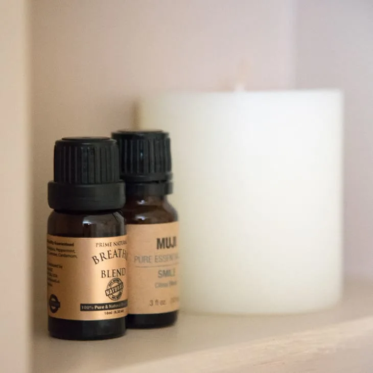 close up view of essential oils and candle in recessed shelves
