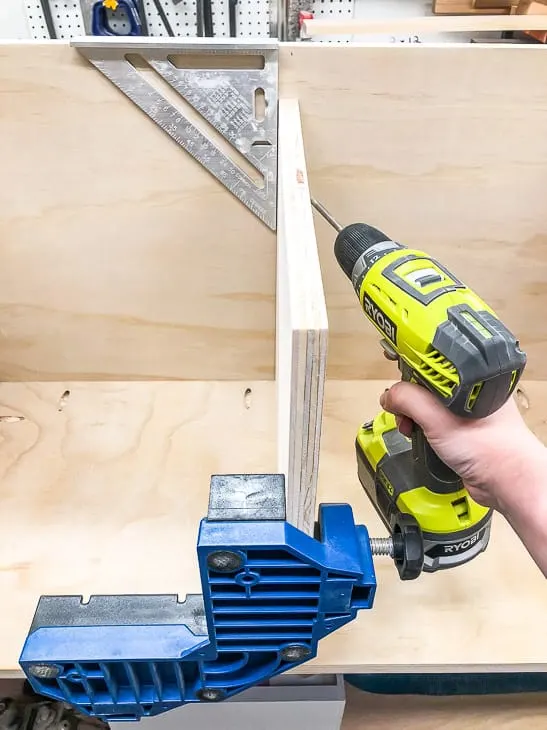 installing the center divider of the shoe cubby bench, making sure it stays straight