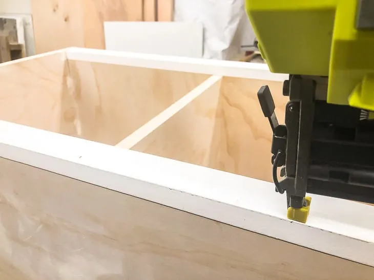 attaching trim to outside of shoe cubby bench with a brad nailer
