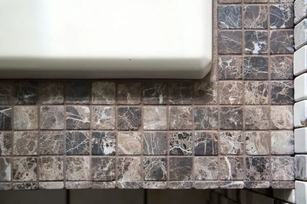 bathtub surround with dark brown tiles next to almond tub