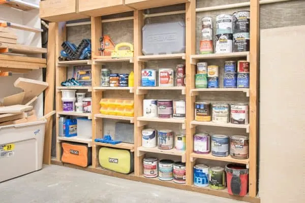 between the studs shelves loaded with paint and tools