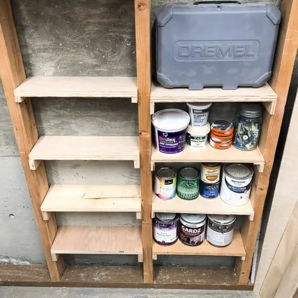 between the studs shelving half filled with paint cans