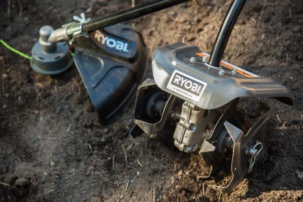 ryobi expand-it system cultivator and string trimmer attachments in empty garden bed