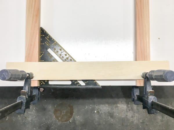 two upright boards clamped to one crosswise slat