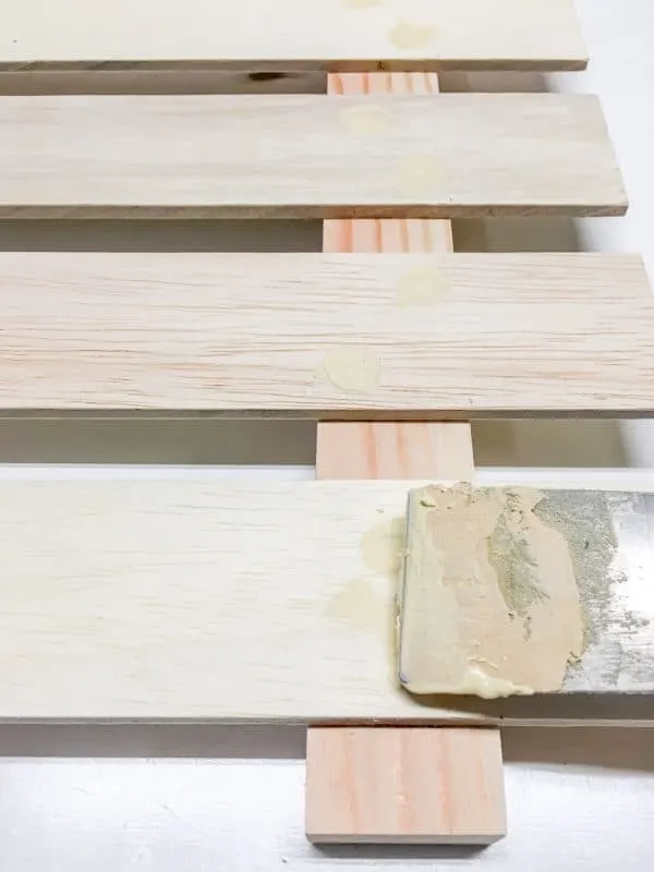 filling nail holes with wood filler and putty knife