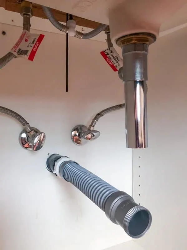 flexible waste pipe attached to wall pipe under sink