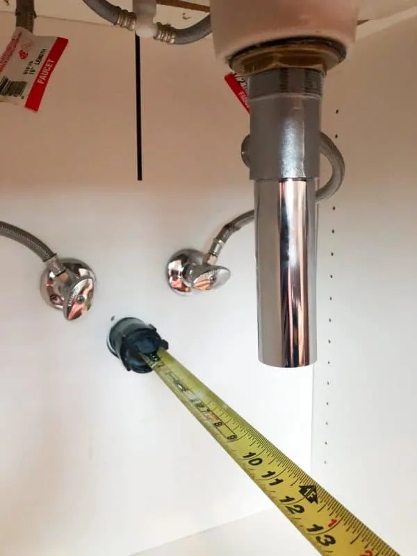 measuring tape measuring under sink plumbing