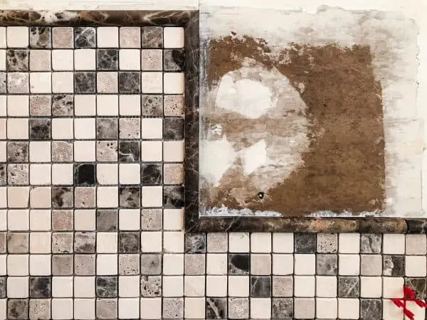 torn drywall paper in corner of tile