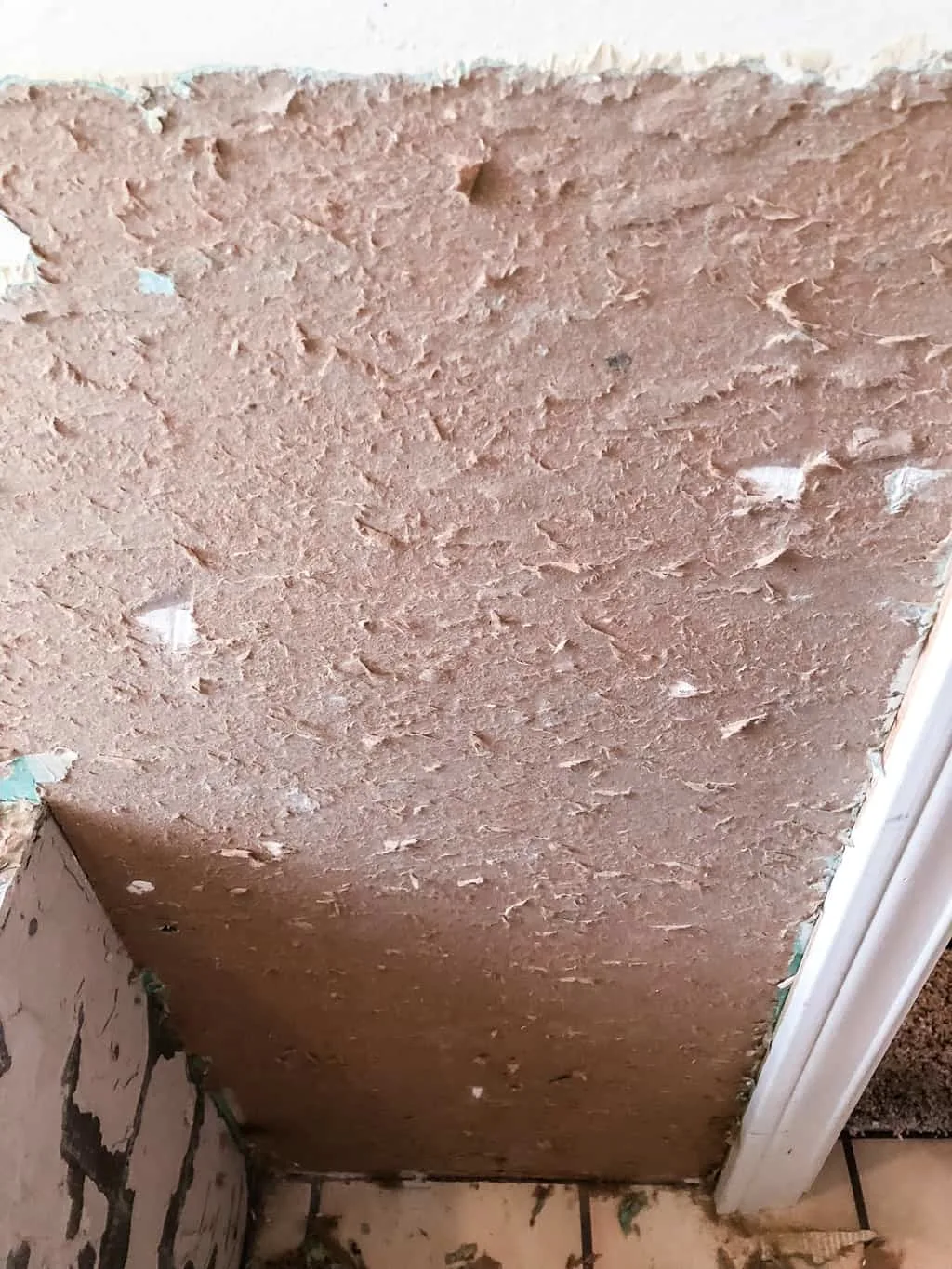 torn drywall paper section with brown layer exposed