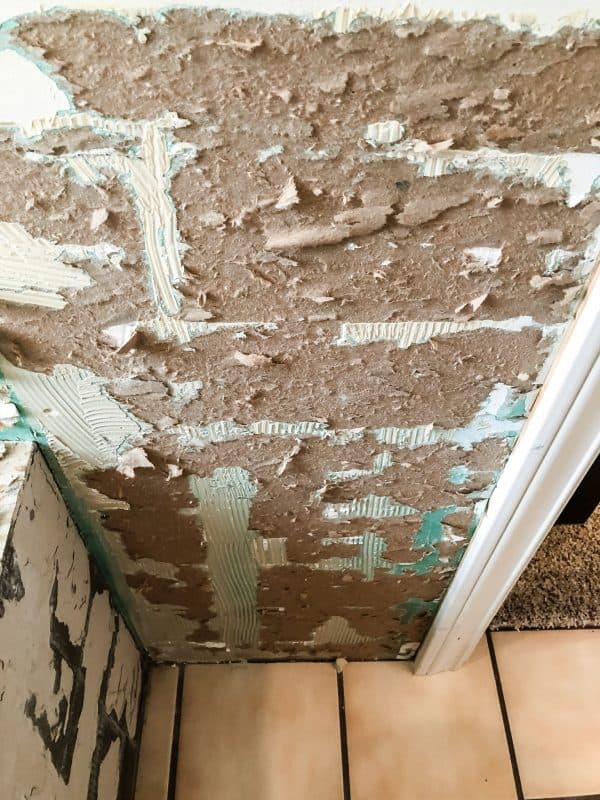 torn drywall paper after tile has been removed