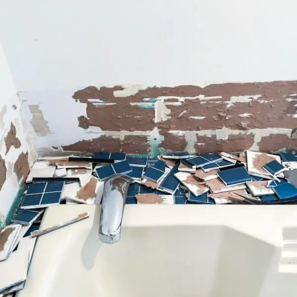 blue bathroom tile removed and torn drywall paper