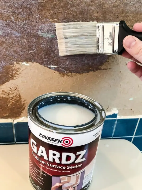 applying Zinsser Gardz to torn drywall paper with paint brush