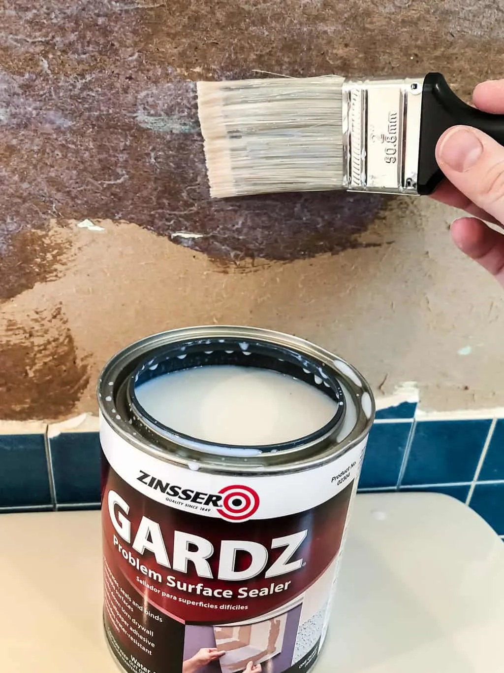 applying Zinsser Gardz to torn drywall paper with paint brush