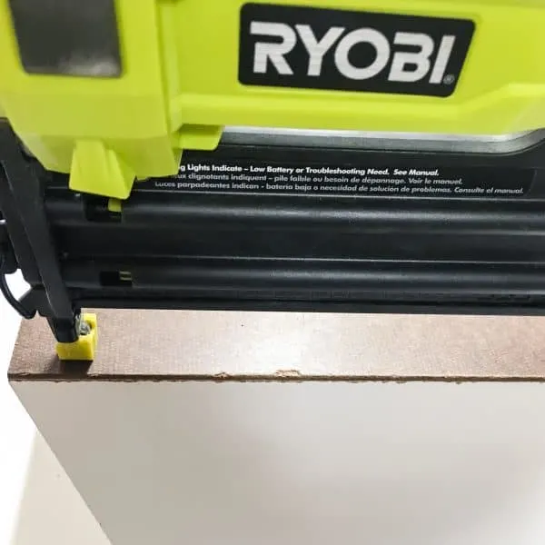 attaching the back of a cordless drill storage rack with a Ryobi Airstrike brad nailer
