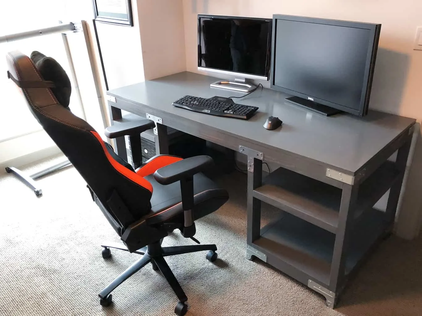 industrial desk with computer monitors and desk chair