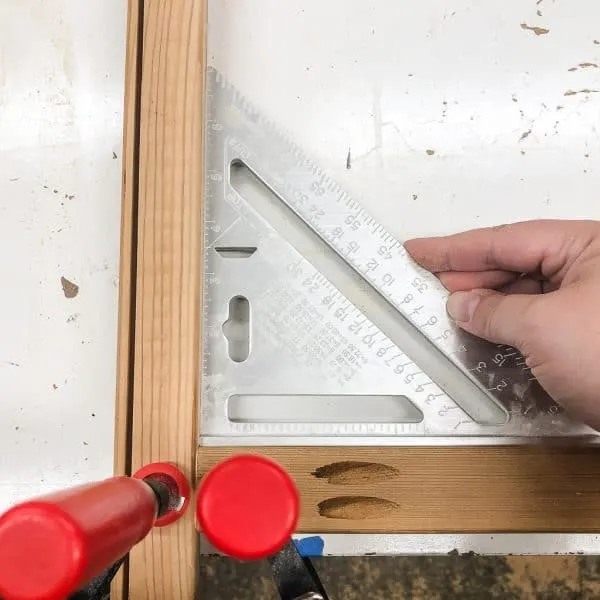 two boards clamped to a workbench and checking for square