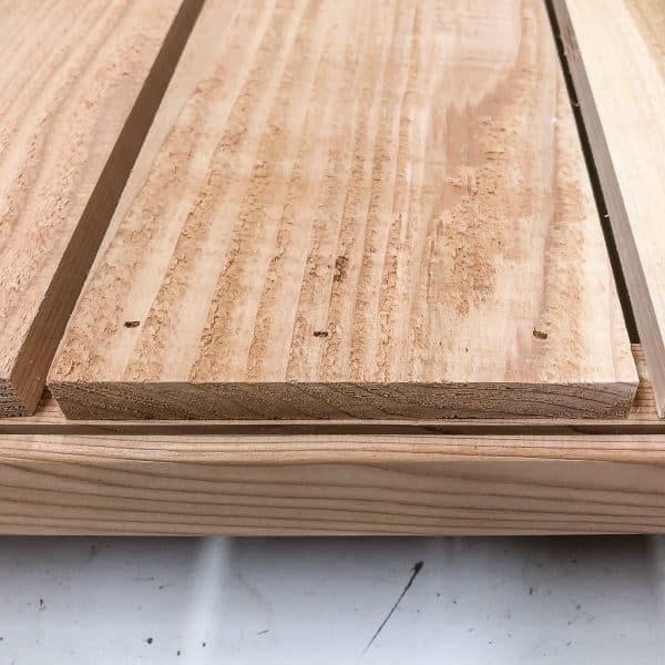 bottom slats of modern planter box lined up behind grooves in frame