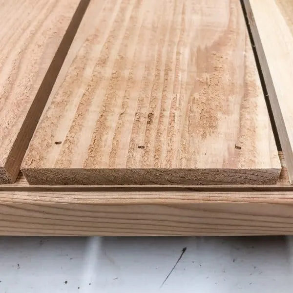 bottom slats of modern planter box lined up behind grooves in frame