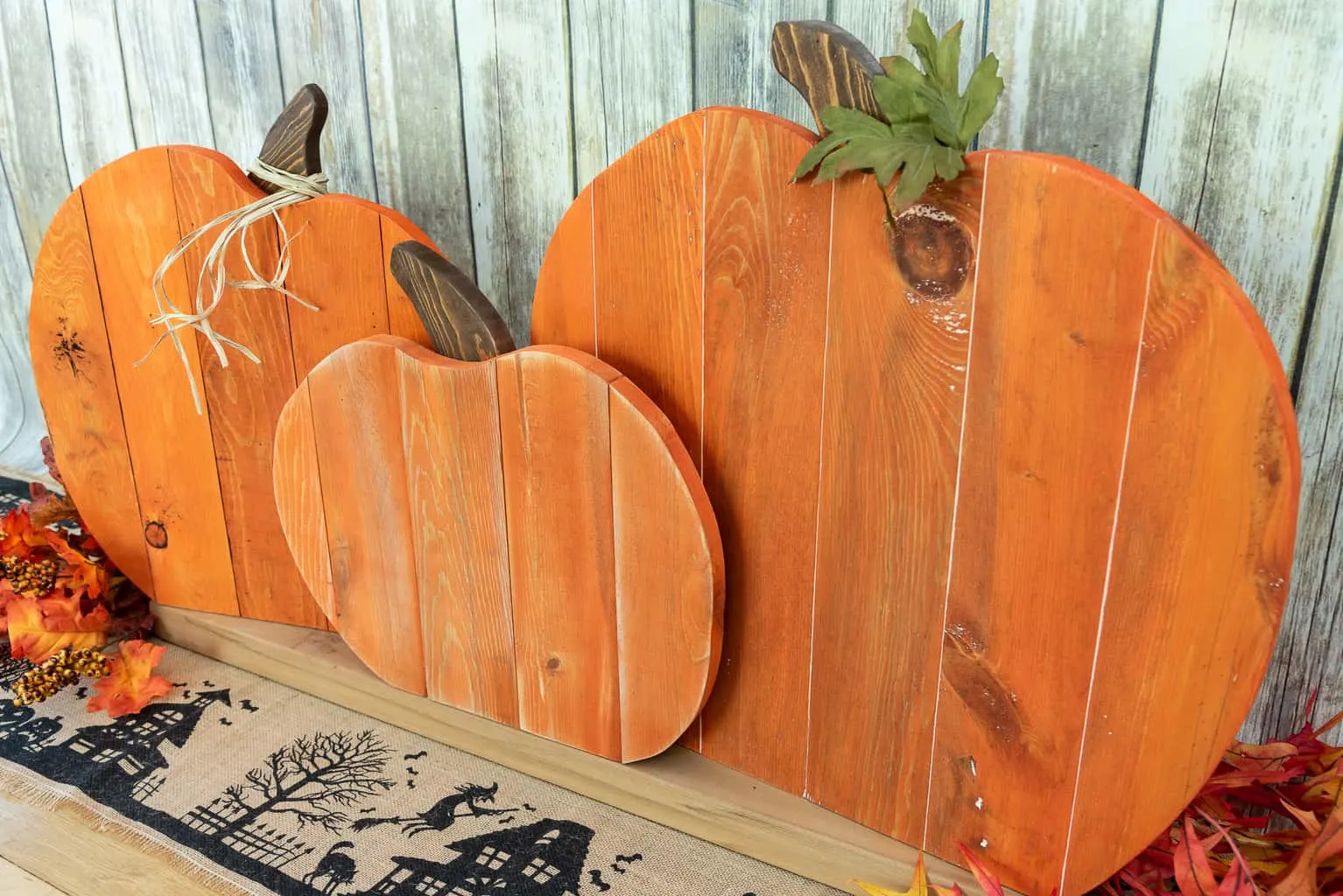 three pallet pumpkins in front of a rustic background