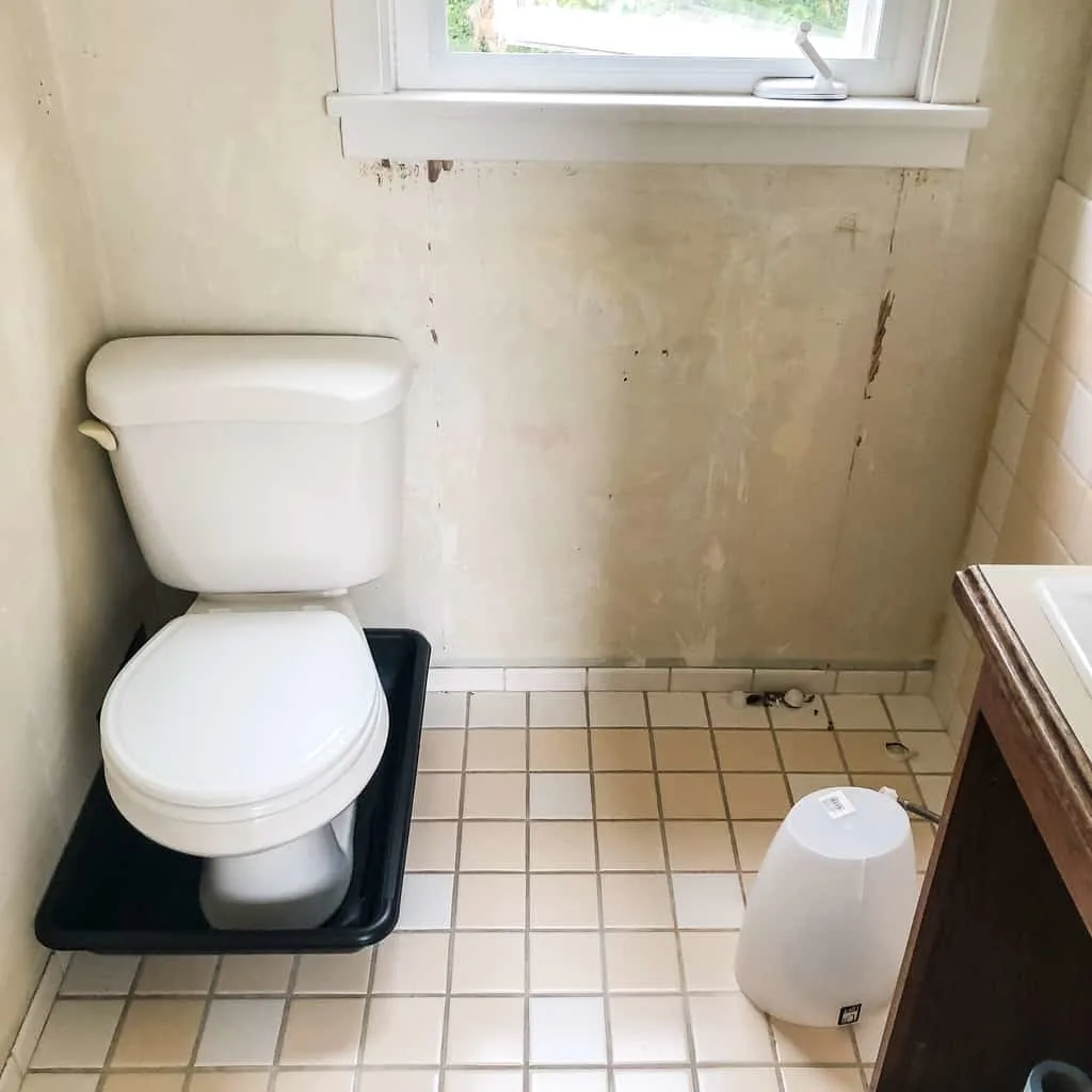 toilet removed from floor and placed in plastic mixing tub