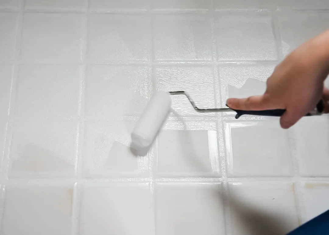 foam roller painting a tile floor