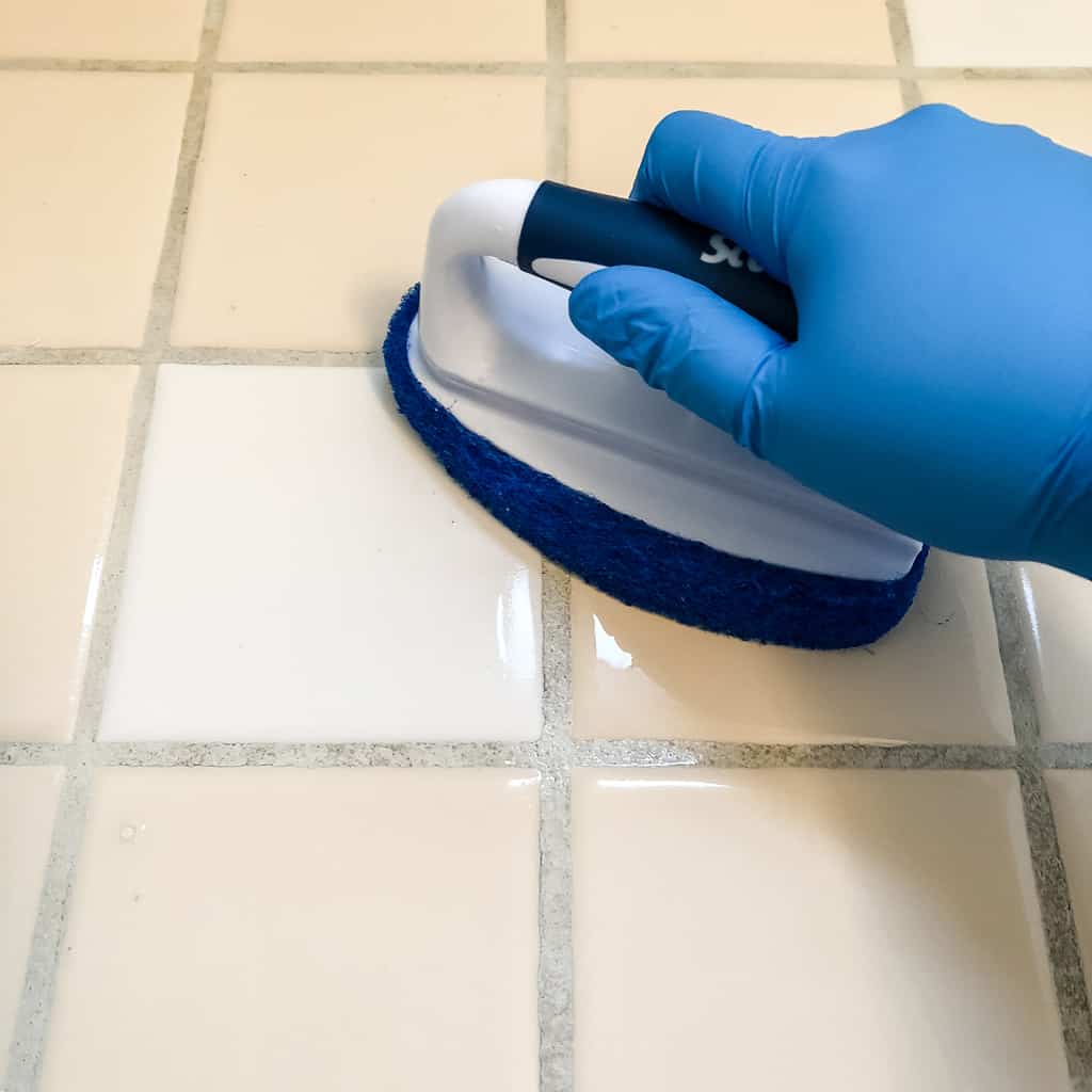 scrubbing tile floor with scrub brush