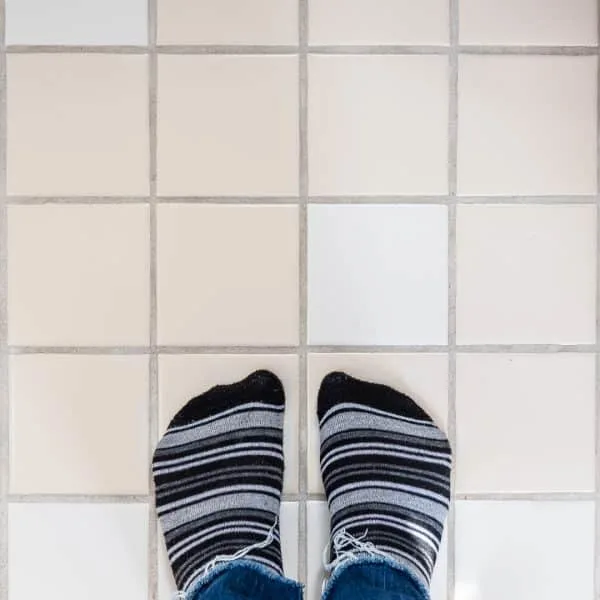 tan and white tiles with feet in striped socks