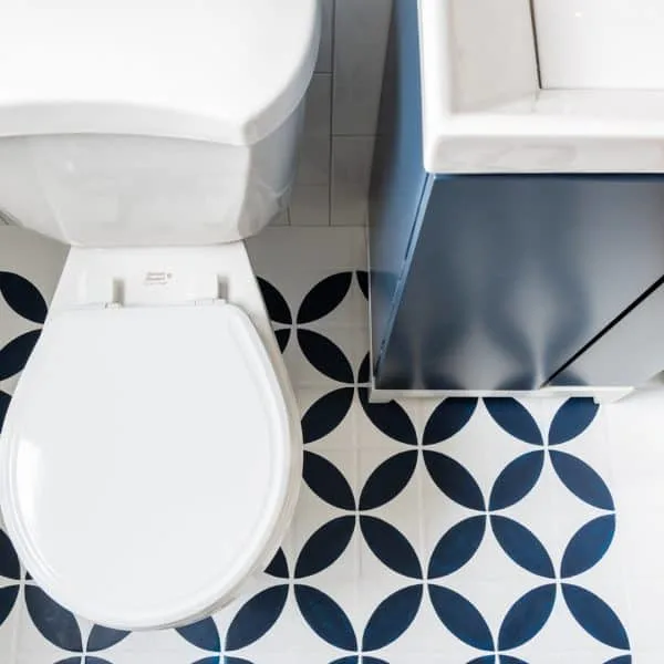 toilet and vanity with bold patterned tile floor