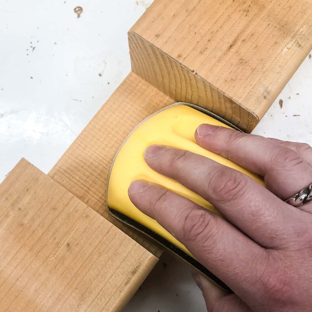 using a sanding block inside half lap joints of a rain barrel stand