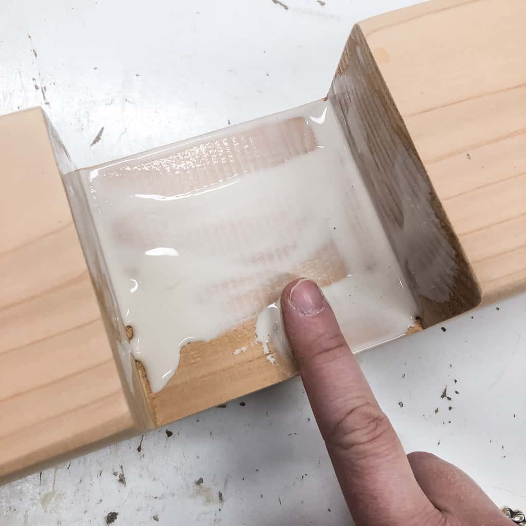 applying wood glue to inside of half lap joint with a finger