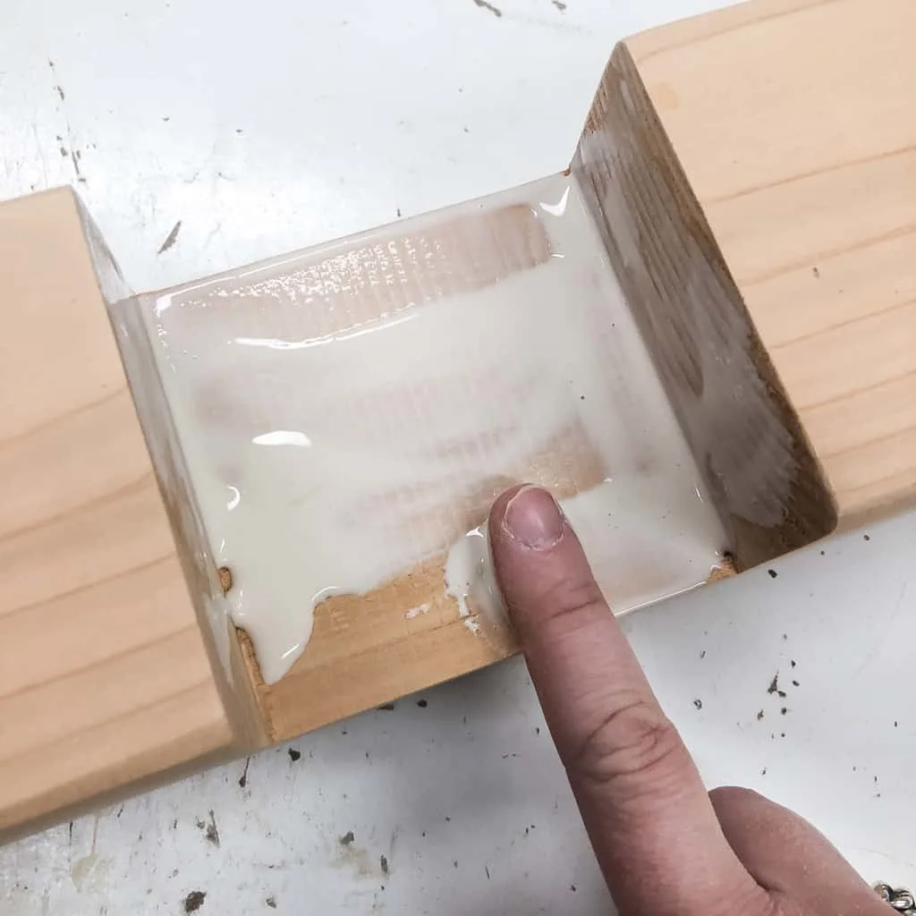 applying wood glue to inside of half lap joint with a finger