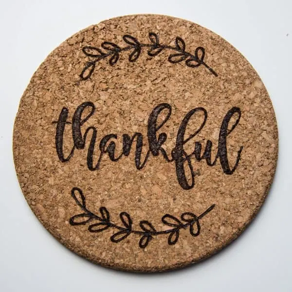 cork trivet with "thankful" wood burned into the surface