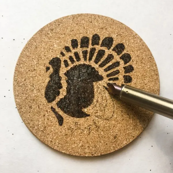 tracing outside edge of traced design with a woodburning tool