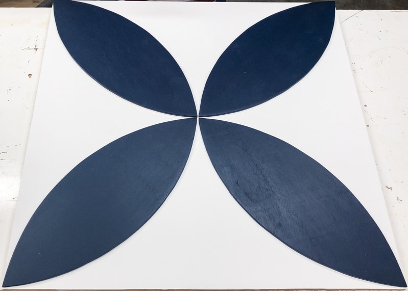 first layer of wood wall art with dark blue petals