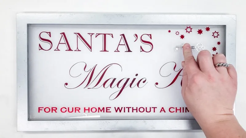 attaching Santa's Magic Key to sign with adhesive clip