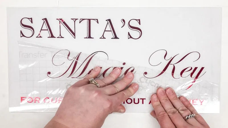 peeling transfer tape off Santa's Magic Key sign lettering