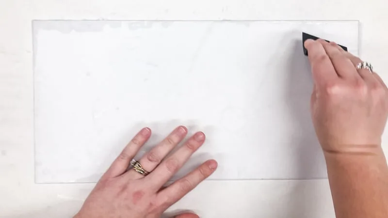 smoothing out air bubbles under contact paper with a scraping tool