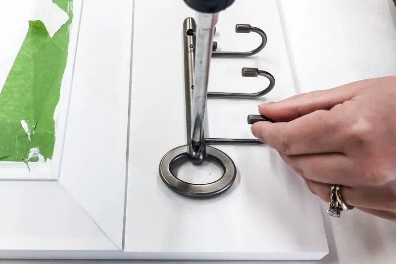 screwing key hooks onto entryway mirror