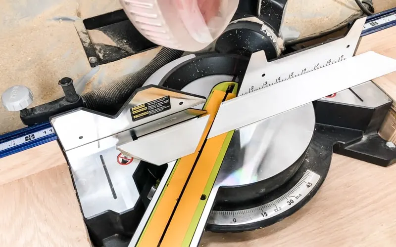 cutting trim at a 45 degree angle on a miter saw to frame an entryway mirror