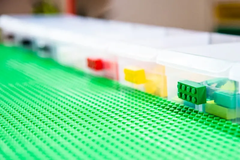 plastic bins on top of IKEA lego table sorted by color