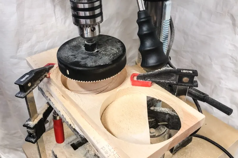 drilling circles out of 1x6 boards with a hole saw mounted in a drill press