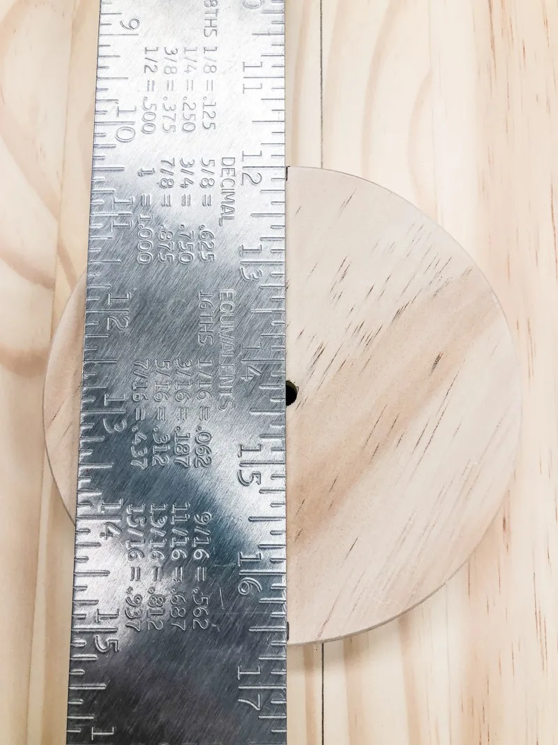 marking center line of wooden circle with metal ruler